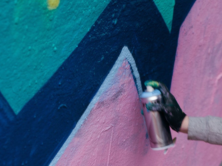 Grafitti artist at work with a spray can. Photo by Clem Onojeghuo